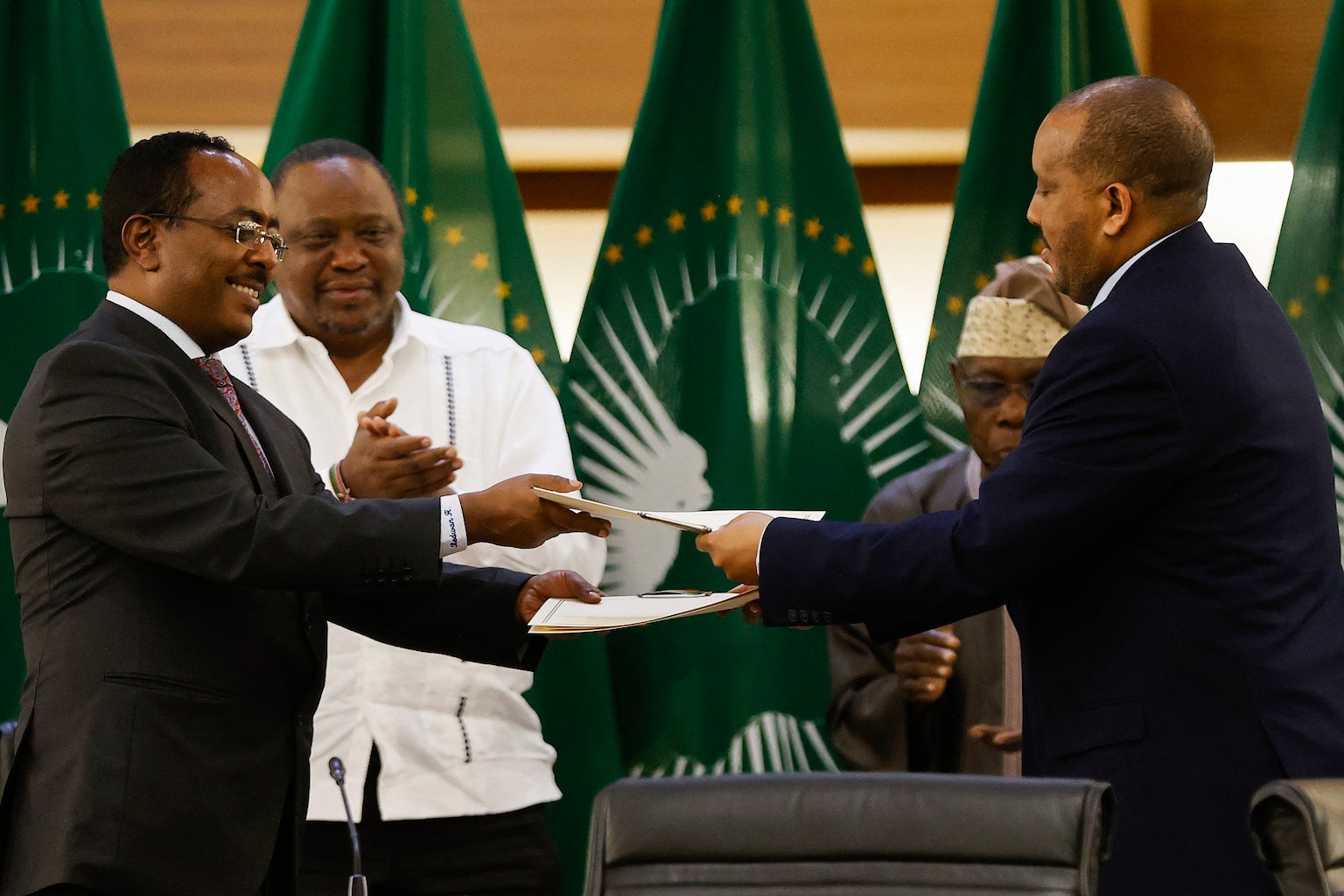 Lead negotiator for Ethiopia's government, Redwan Hussein, left, and lead Tigray negotiator Getachew Reda, right, sign documents during the peace talks in Pretoria, South Africa on Nov. 2, 2022.