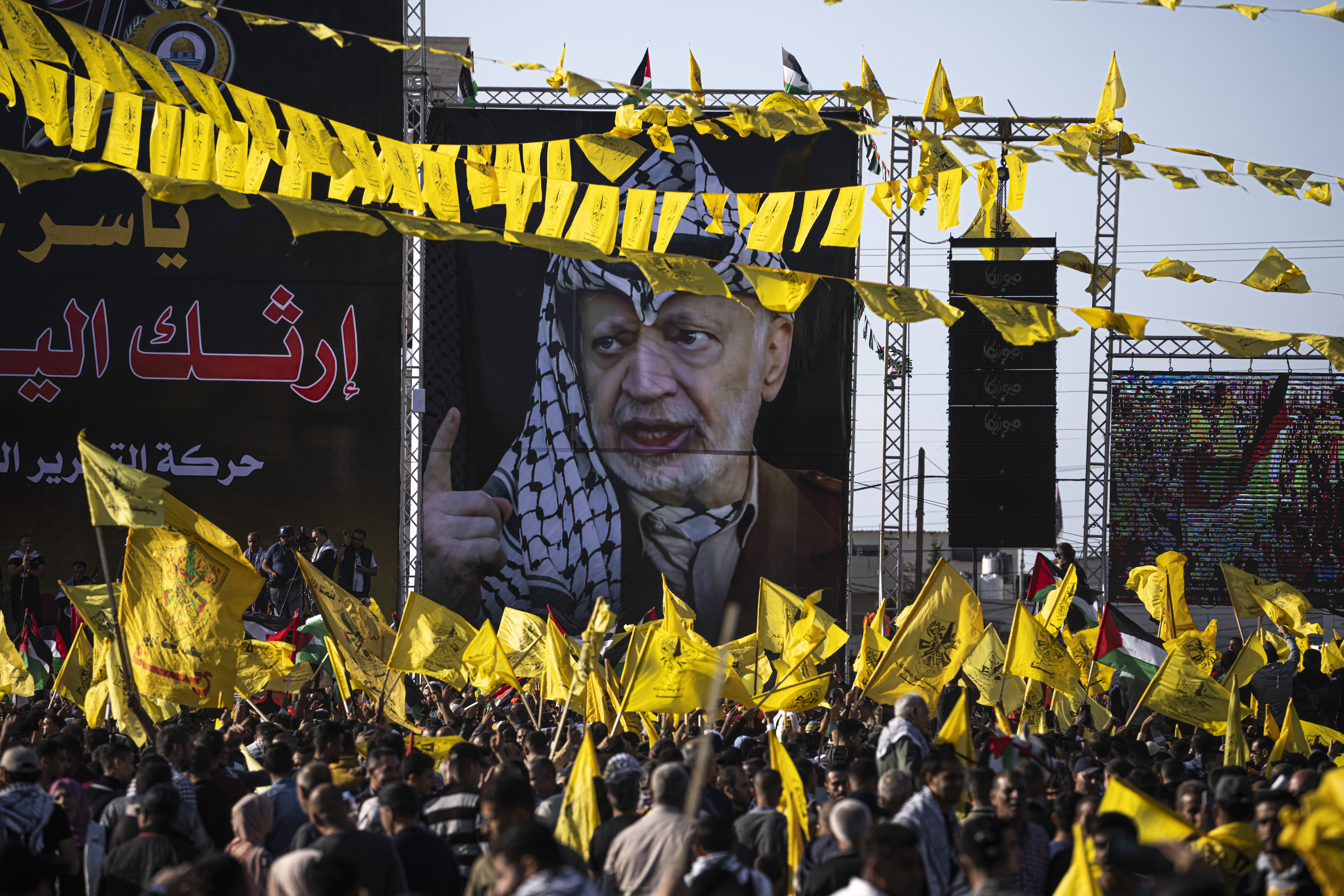 FILE - Palestinians chant slogans and wave yellow Fatah movement flags during a rally marking the 18th anniversary of the death of Fatah founder and Palestinian Authority leader Yasser Arafat in Gaza City, Thursday, Nov. 10, 2022. 