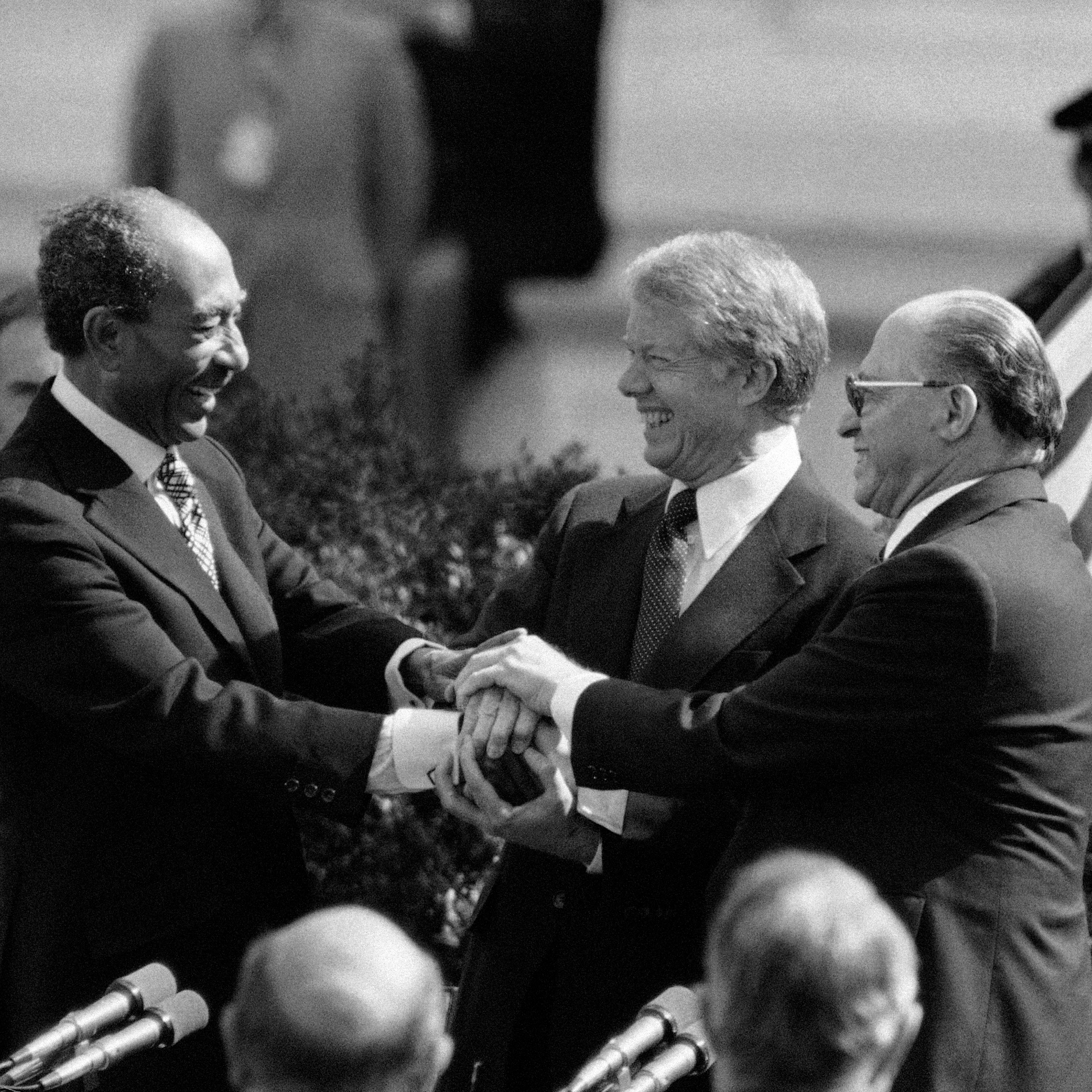 Egyptian President Anwar Sadat, President Jimmy Carter, and Israeli Prime Minister Menachem Begin clasp hands after signing the Middle East Peace Treaty at the White House in Washington.