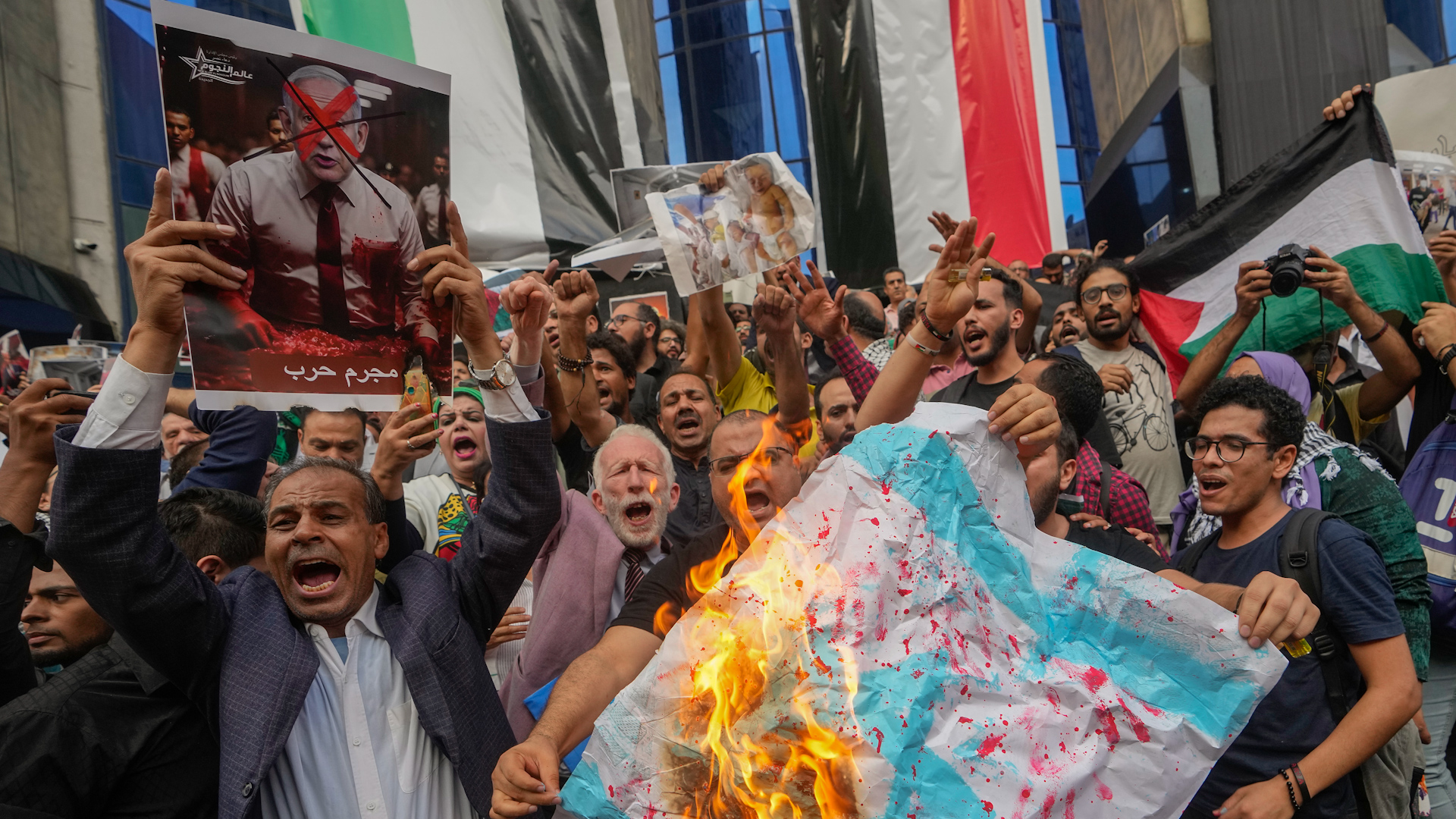Egyptian protesters burn an Israeli flag during a demonstration to show solidarity with Palestinians, in front of the Journalists Syndicate in Cairo on October 18.
