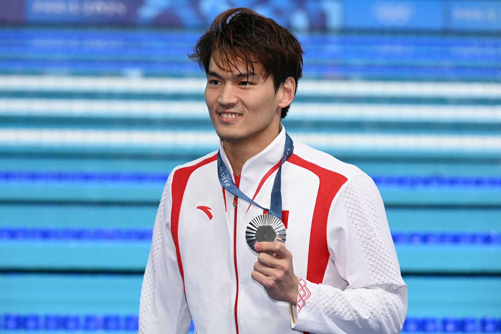 Silver medallist China’s Xu Jiayu poses with his medal after the men’s 100m backstroke swimming event during the Paris 2024 Olympic Games 
PHOTO: JONATHAN NACKSTRAND / AFP