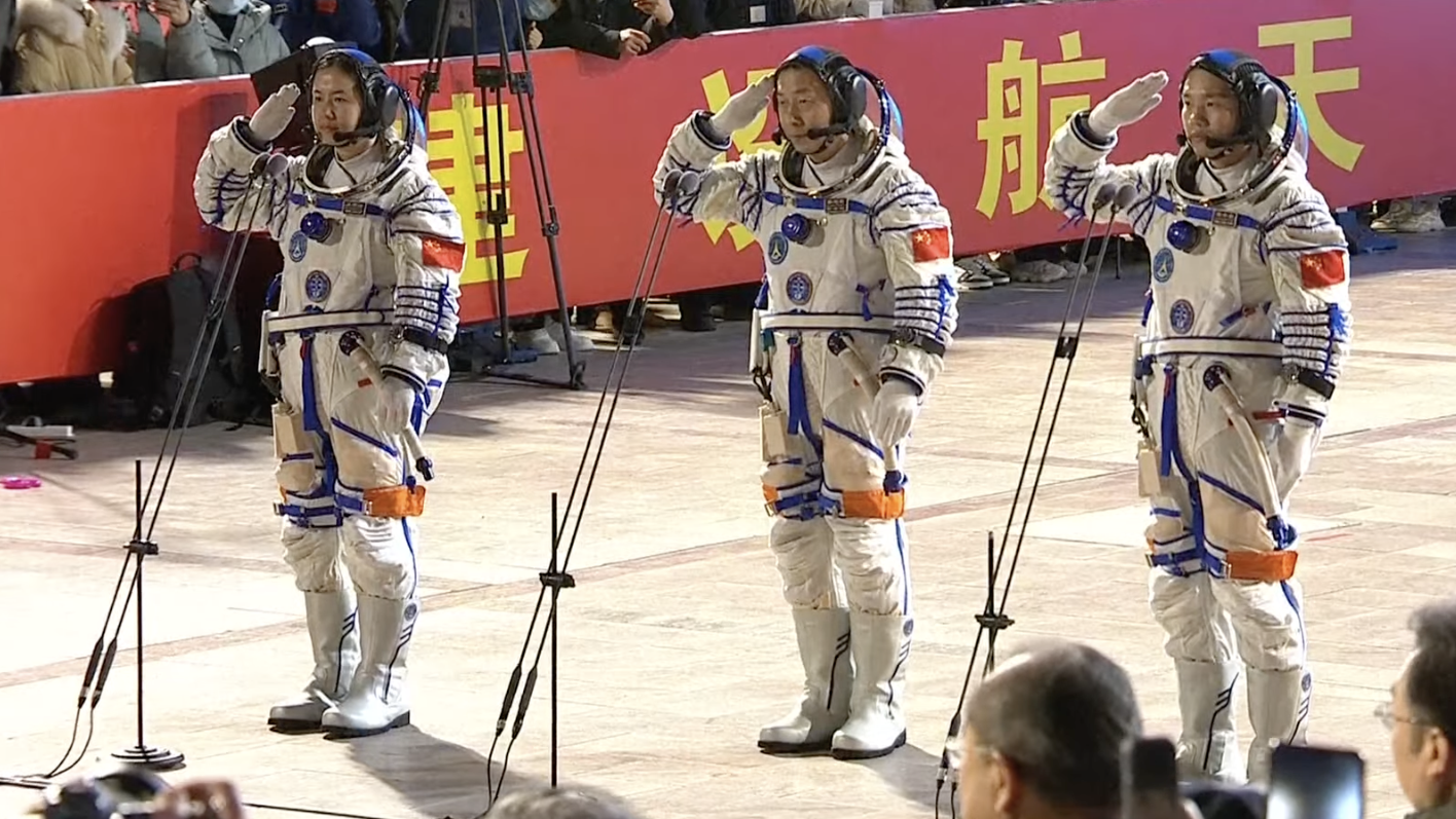 Chinese taikonauts Cai Xuzhe (C), Song Lingdong (L) and Wang Haoze salute ahead of the Shenzhou-19 spaceflight mission.