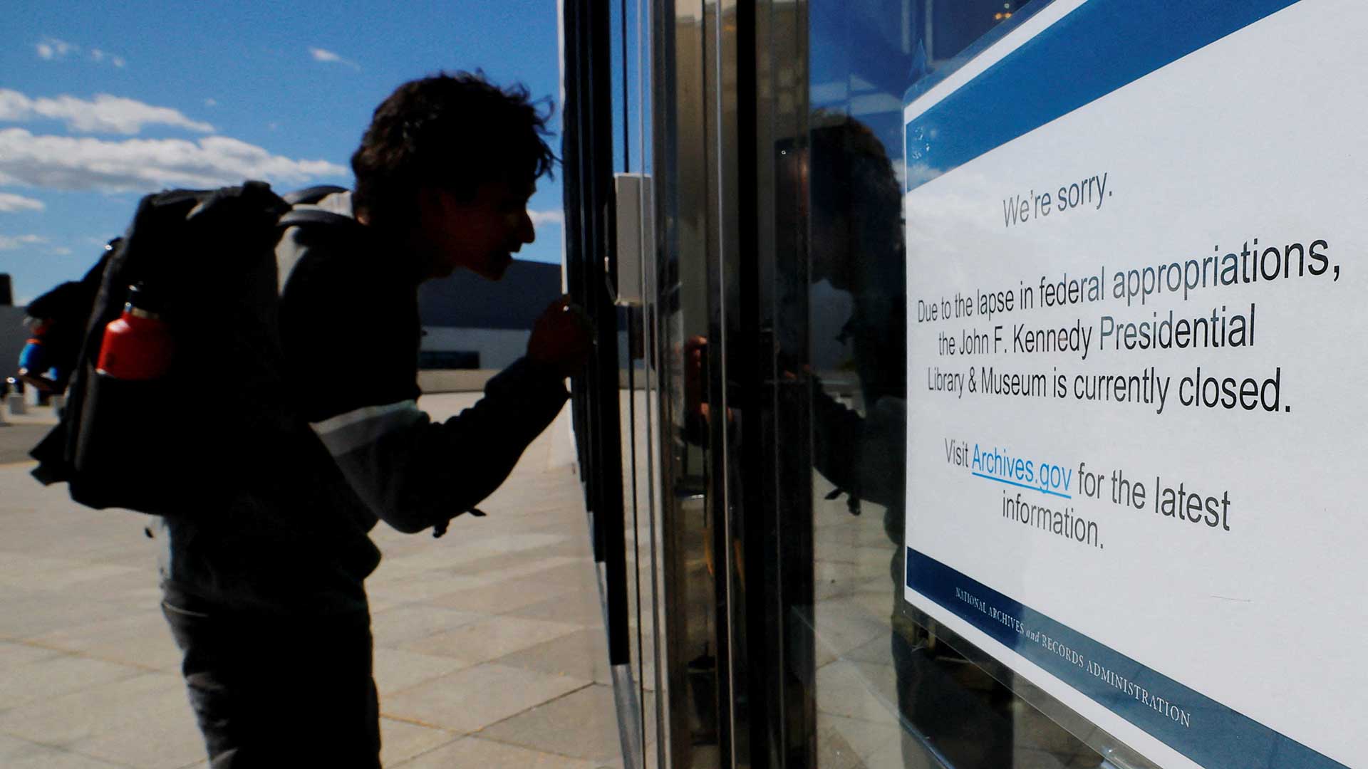 A would-be visitor looks into the John F. Kennedy Presidential Library and Museum which is closed, on the first day of a partial U.S. government shutdown, in Boston, Massachusetts, U.S., October 1, 2025. REUTERS/Brian Snyder