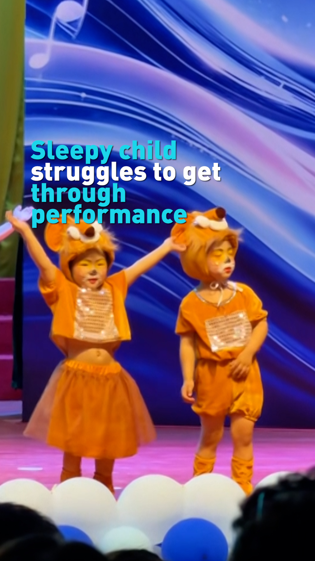 Sleepy child struggles to stay awake while performing on stage 